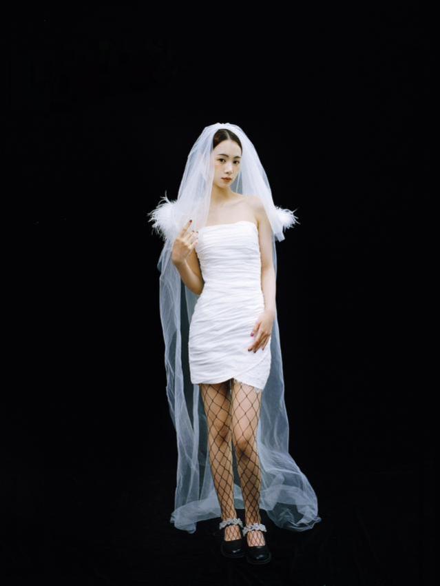 The wedding dress is paired with black fishnet socks to show the unique charm of girls.